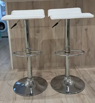 Taburetes altos blancos y plateados