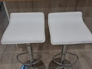 Taburetes altos blancos y plateados