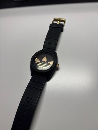 Reloj Adidas Negro con detalles en dorado.