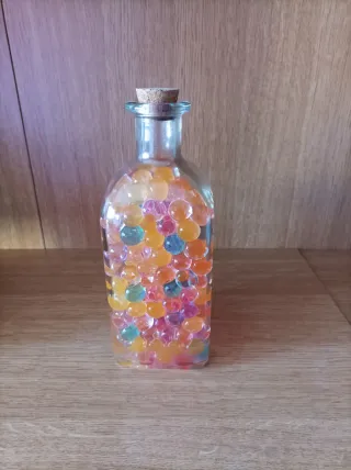 Botella con bolitas de colores .