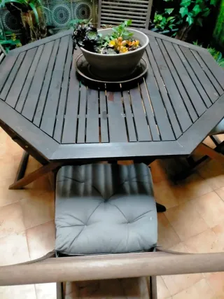Mesa de madera para exterior con 5 sillas.
