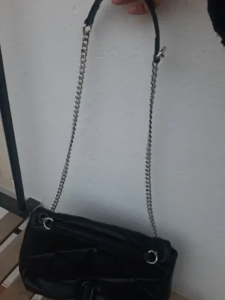 Bolso negro con cadena plateada ajustable larga y