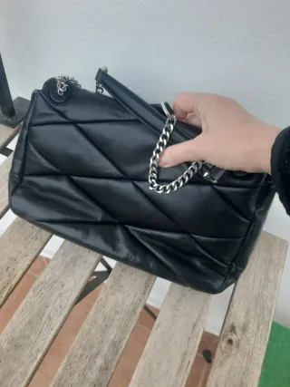 Bolso negro con cadena plateada ajustable larga y