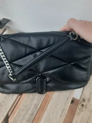 Bolso negro con cadena plateada ajustable larga y