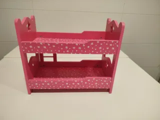 Cama de muñecas rosa con estrellas