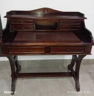 Escritorio de madera marrón con bandeja extraíble.