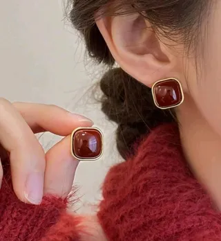 Pendientes cuadrados rojos y dorados.