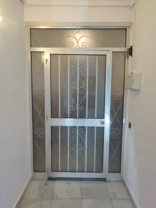 Puerta de aluminio con reja decorativa