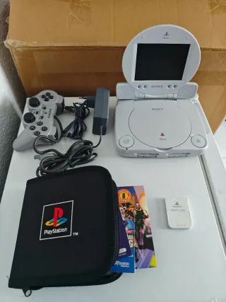 Consola PlayStation con mando y juegos