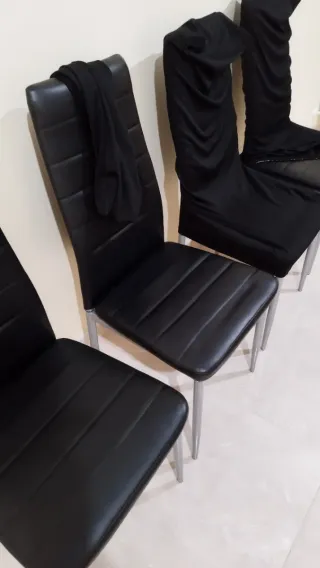 Juego de 4 sillas negras, con sus fundas.