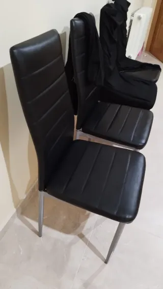 Juego de 4 sillas negras, con sus fundas.