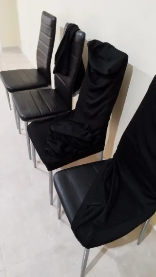 Juego de 4 sillas negras, con sus fundas.
