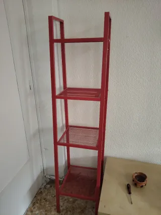 Estantería metálica roja y reloj