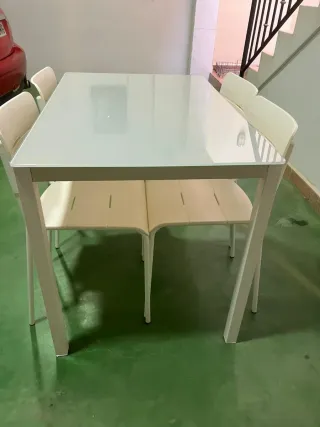 Mesa cristal y 4 sillas blancas