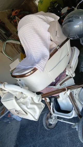Carro de bebé blanco y dorado