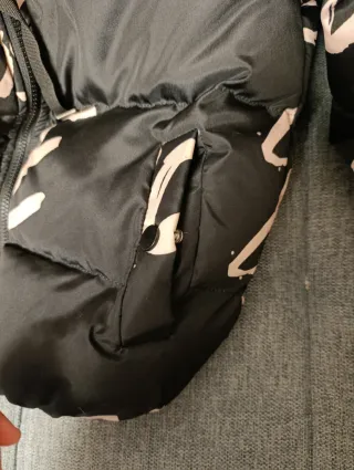 Abrigo negro acolchado con letras beige