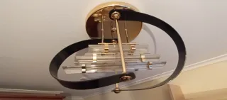 Lámpara de pared dorada y negra con cristal