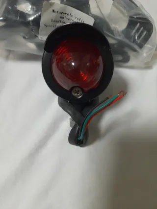 Faro trasero moto con soportes metálicos.
