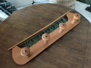 Perchero de madera con cuerdas verdes