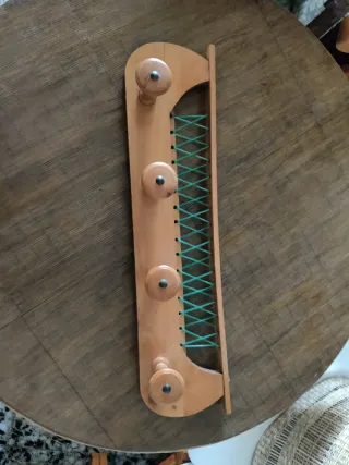 Perchero de madera con cuerdas verdes