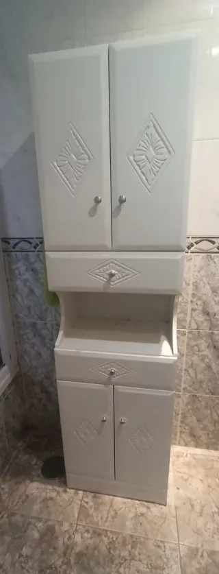 Mueble de baño blanco con espejo y toallero