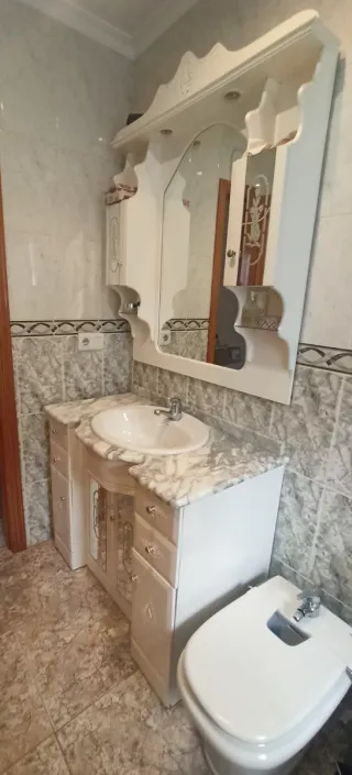 Mueble de baño blanco con espejo y toallero