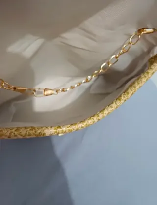 Bolso de mano tejido con cadena dorada