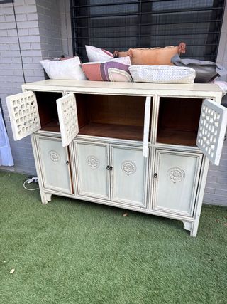 Aparador alto de madera color crema.