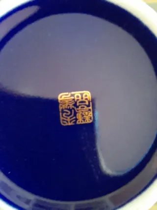 Jarrón chino azul y dorado con adornos orientales.