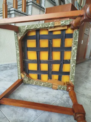 Sillón tapizado verde con reposabrazos