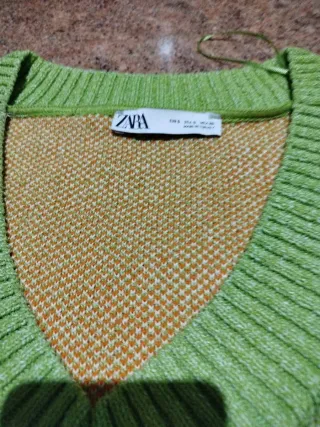 Chaleco verde con flores naranjas y blancas