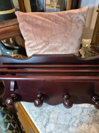 Perchero de madera oscuro con pomos