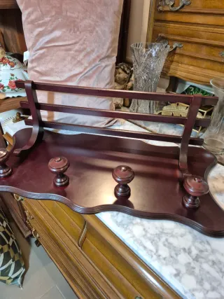 Perchero de madera oscuro con pomos