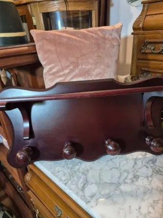 Perchero de madera oscuro con pomos