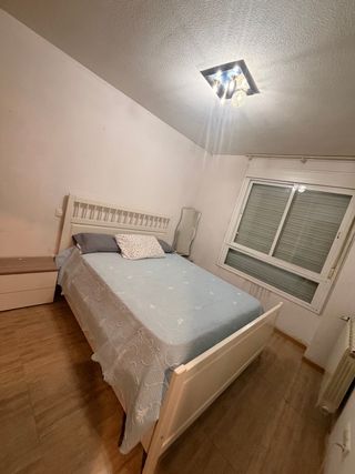 Cama de madera blanca con colcha azul