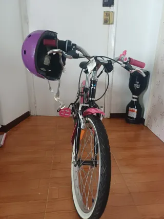 Bicicleta infantil rosa con casco