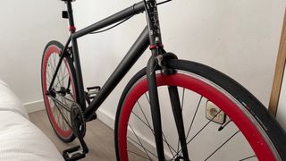 Bicicleta urbana negra con ruedas rojas fixie