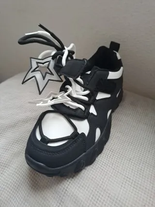 Zapatillas negras y blancas con estrellas.
