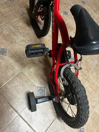 Bicicleta infantil roja con ruedines