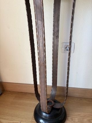 Mesa auxiliar redonda de metal y mármol negro.