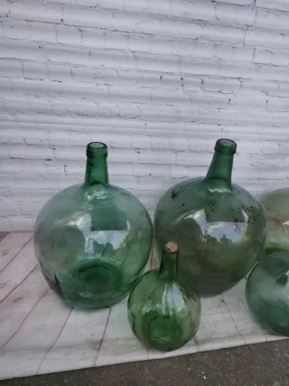 Damajuanas de vidrio verdes y transparentes