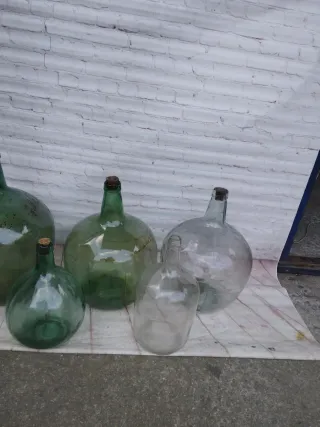 Damajuanas de vidrio verdes y transparentes
