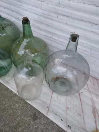 Damajuanas de vidrio verdes y transparentes