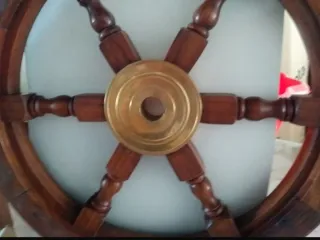 Timón de madera decorativo con detalles en latón.
