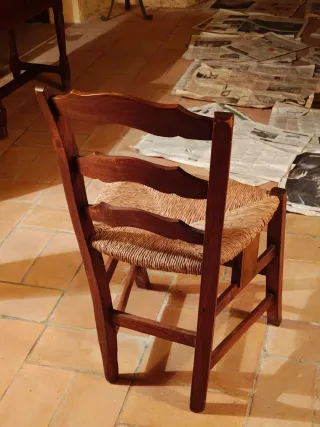 Silla antigua de madera con asiento de yute.