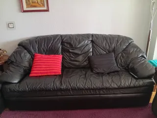 Sofá de piel negro y cojín rojo