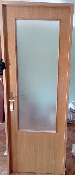 Puerta maciza de madera con manilla dorada