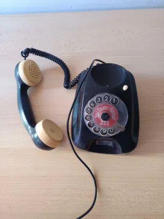 Teléfono antiguo de disco negro y beige