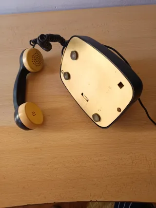 Teléfono antiguo de disco negro y beige