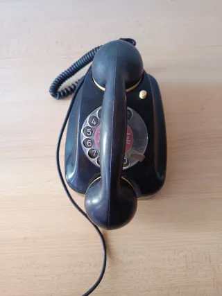 Teléfono antiguo de disco negro y beige